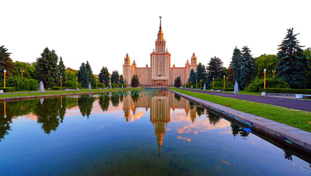 istock Wide angle panoramic view of sunset campus of old university with pond reflections and swimming red ducks isolated on white background 1255744570
