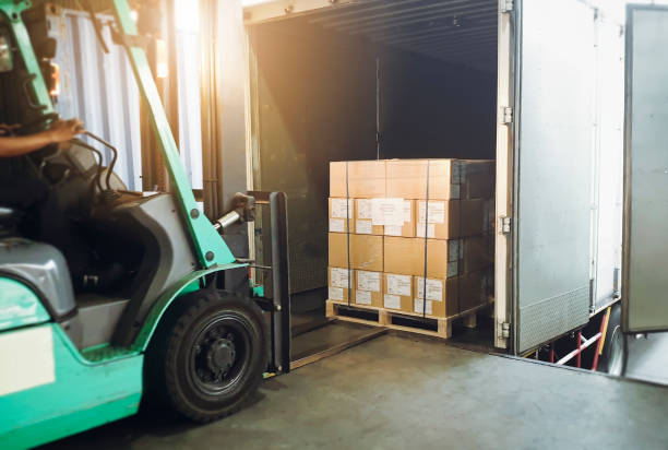 istock Forklift loading shipment goods pallet into container shipping truck. Cargo freight, Logistics and transportation. 1255745289