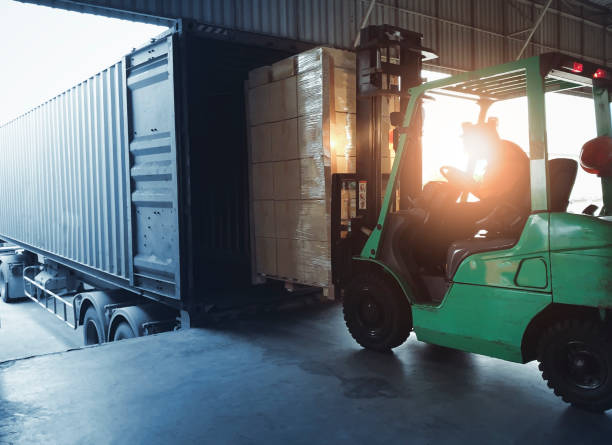 Forklift loading shipment goods pallet into container shipping truck. Cargo freight, Logistics and transportation.