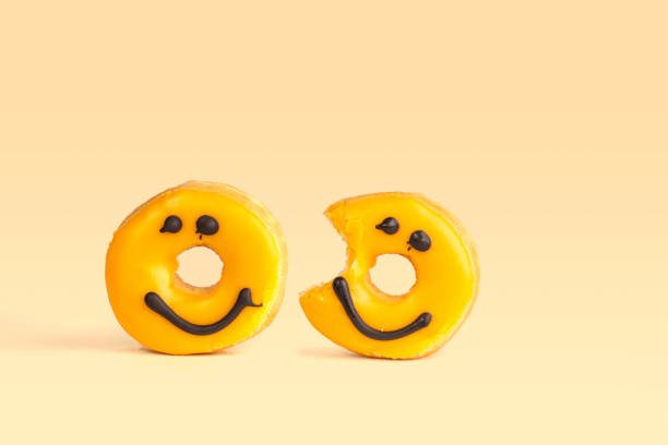istock two Fresh yellow donuts with a chocolate smile 1255745753