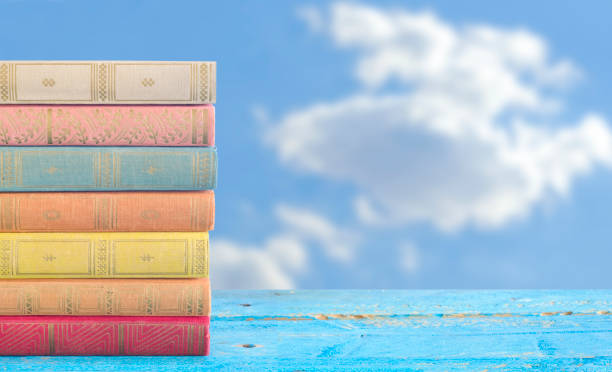 stapel von büchern auf bewölktem blauen himmel hintergrund, kostenloser kopierraum - picture book book old leather stock-fotos und bilder