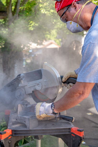 istock Man uses a miter saw to cut bricks for a backyard project 1255748462
