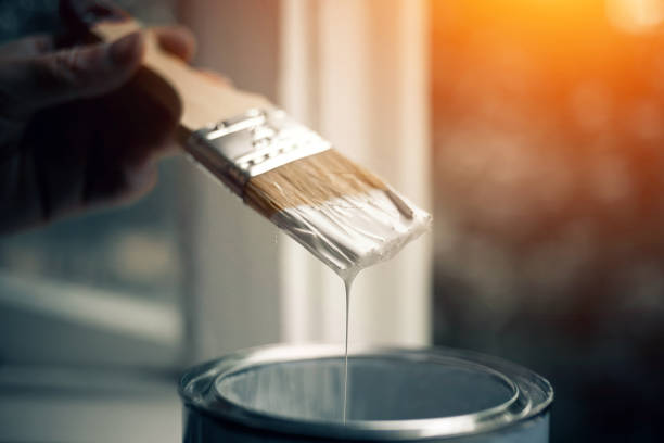 istock Can of paint and a brush in white paint. 1255748628