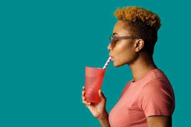 profil portret fajnej młodej kobiety w kolorze różowym trzymając kubek do picia i papierową słomę - water drinking glass drink zdjęcia i obrazy z banku zdjęć