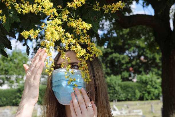 istock Impossibility of flower smelling through face mask goldenrain tree 1255751775