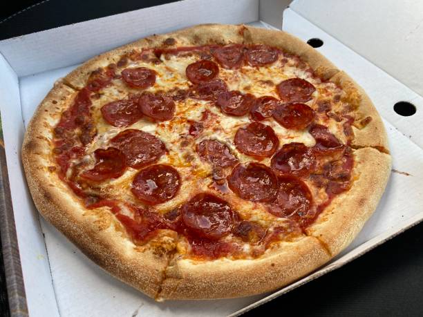 istock Pizza peperoni and cheese in open box close up 1255755431