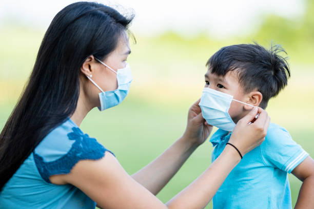 istock Mother and son wearing protective face masks during COVID-19 1255757668