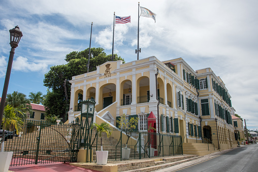Christiansted, St. Croix, VI-October 22,2019: Government House with flags in downtown Christiansted under a blue sky with clouds in the US Virgin Islands