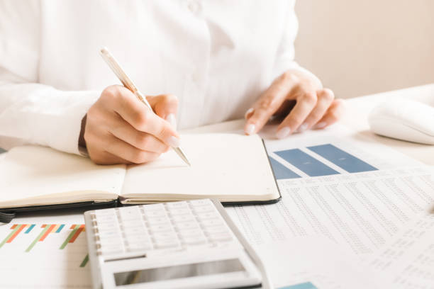 istock manager makes notes in financial statements. metal pen in hand 1255760745