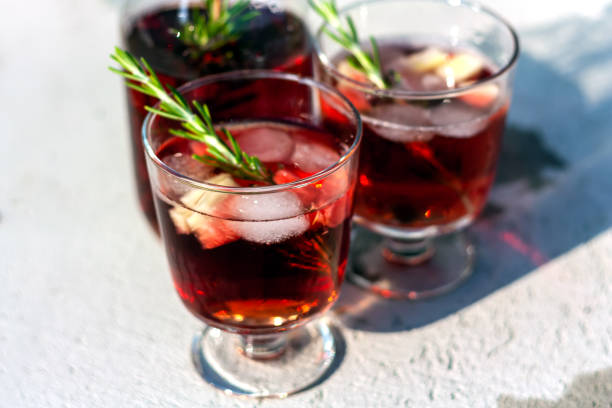 istock Two glasses and carafe with red refreshing summer drink or red wine, ice cube, pieces of watermelon and rosemary sprigs. Summertime concept. Selective focus. 1255762611