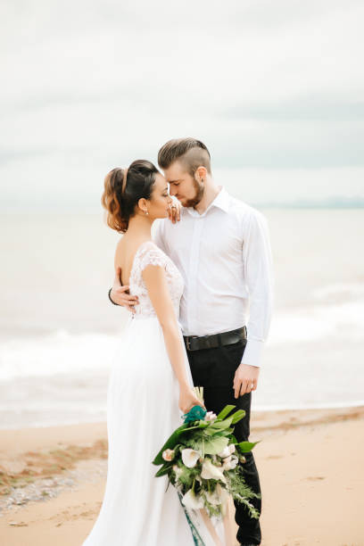 istock young couple groom with the bride on a sandy beach 1255763159