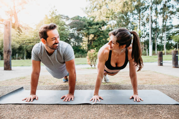 istock Man and woman doing exercises outdoors 1255764640