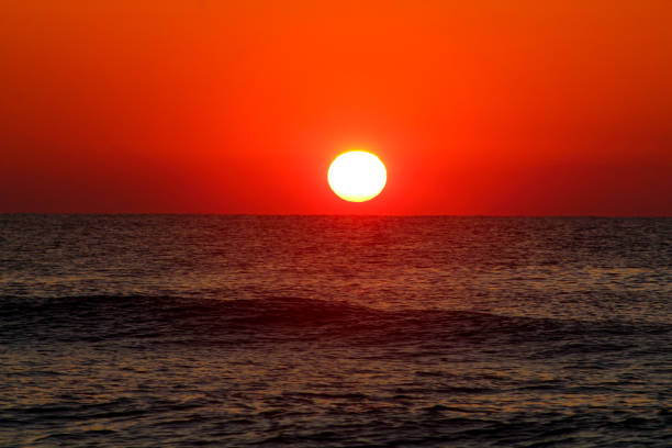 istock Sun rising over the ocean 1255766535