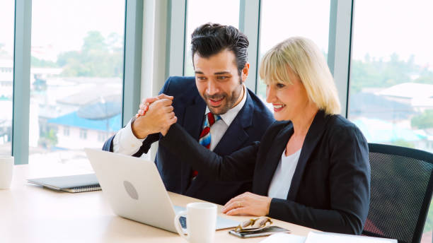 istock Two happy business people celebrate at office 1255767990