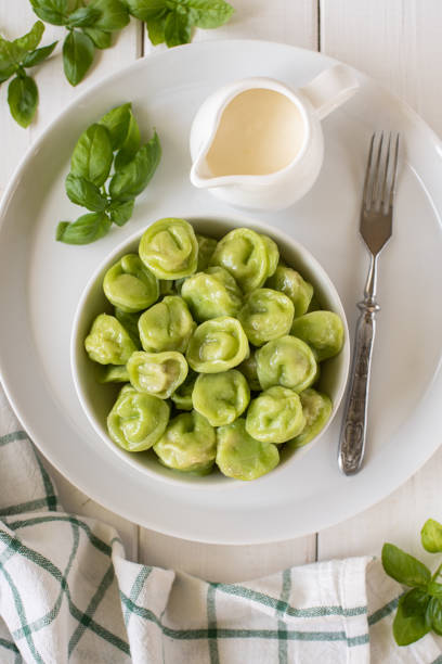 istock Green spinach dumplings with meat in a white bowl on a white wooden background 1255768162