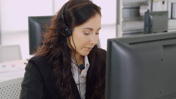 istock Business people wearing headset working in office 1255770239