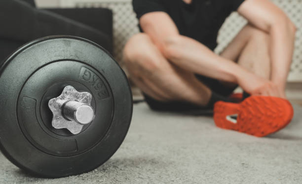 istock Man tying shoelaces before exercise. Home fitness training concept. 1255771941