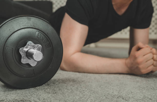 istock Man doing plank exercise. Home fitness training concept. 1255771944