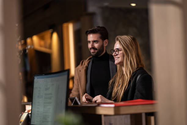 istock Couple arriving in hotel lobby, check in desk 1255773736