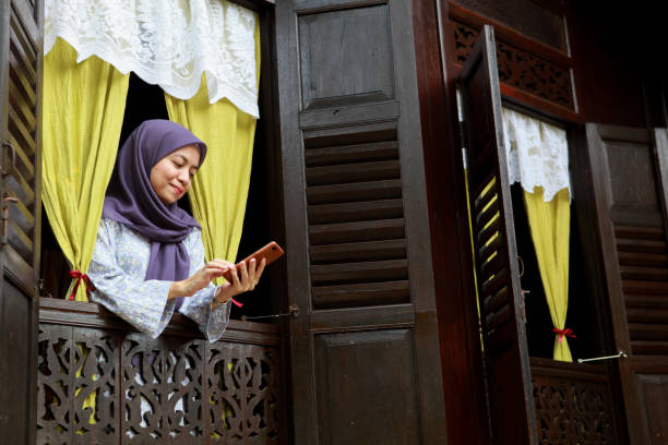 istock A Malay Muslim Woman Standing by The Window and Using Mobile Phone 1255777047