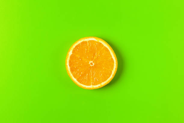 istock orange slice on a green background macro. place for the label 1255777098