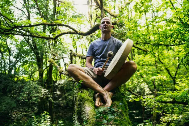 Photo of Adult man playing shamanic drum