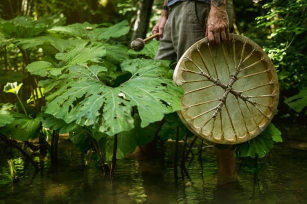 Adult man playing shamanic drum stock photo