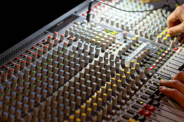 istock Hands on mixing console in music recording studio 1255780963