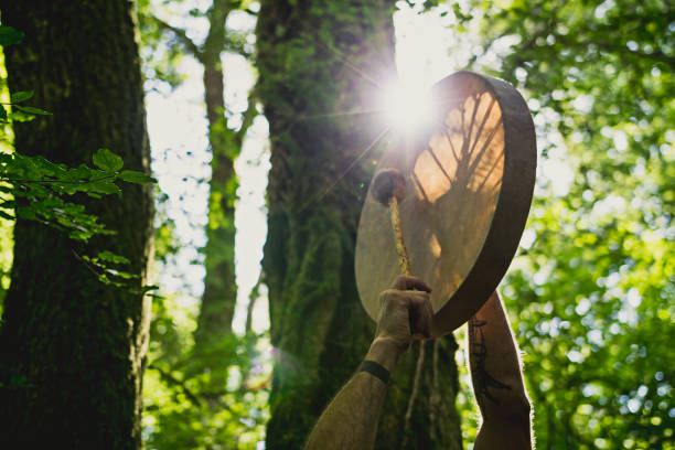 Adult man playing shamanic drum stock photo