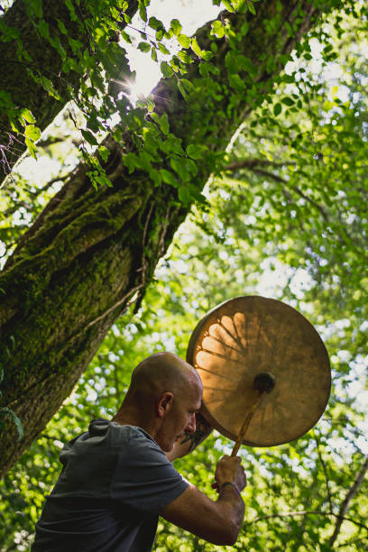 Adult man playing shamanic drum stock photo