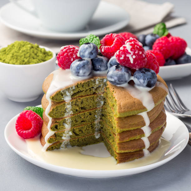 istock Cuted stack of matcha pancakes served with condensed milk, blueberry and raspberry on a white plate, square 1255782526