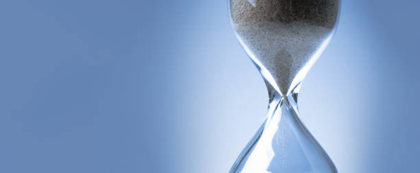 istock Sand flowing through an hourglass concep 1255783591