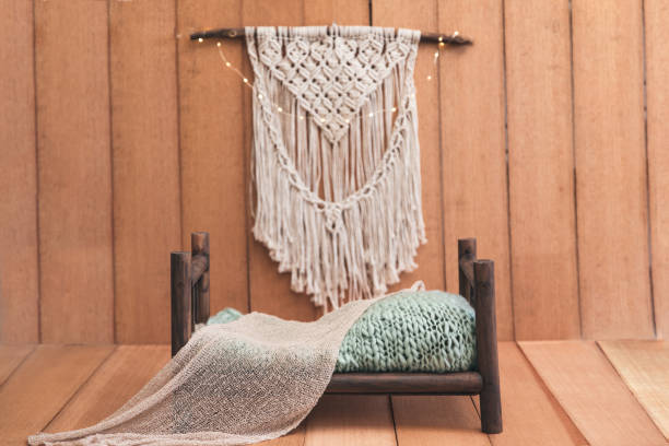 istock Newborn digital background - wooden bed with rustic throw and macrame on wooden background. Modern Scandinavian photography backdrop. 1255784803