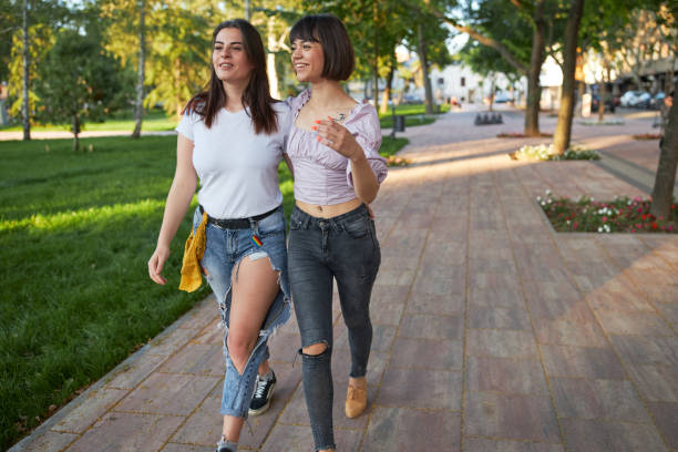 istock Happy young embraced girlfriends in love enjoying their walk 1255785590