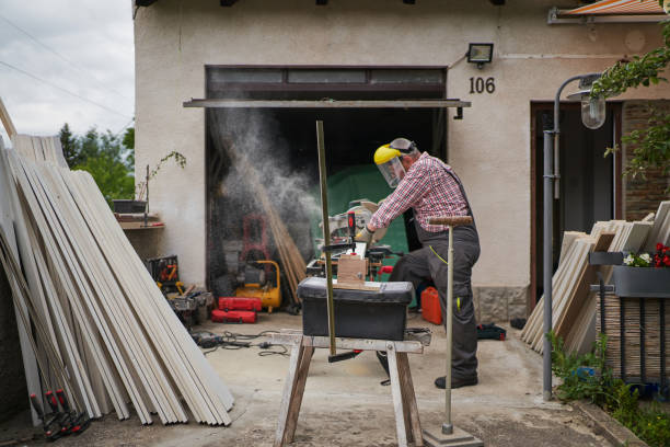 istock Senior carpenter with a protection cutting planks with electrical saw at his workshop 1255785893