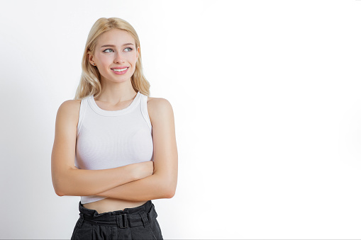 Young happy woman looking up with arms crossed