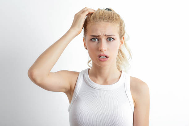 Uncertain young woman scratching her head