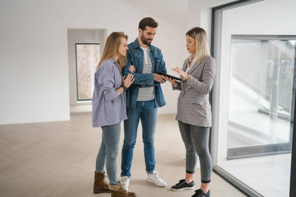 istock Modern real estate agent using a digital tablet so the client can see the blueprint of the house 1255787404