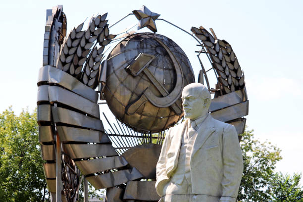 Monument to Lenin against coat of arms of the USSR Moscow, Russia - July 2020: Monument to Vladimir Lenin, the leader of the russian proletariat, against coat of arms of the USSR in Muzeon park of Moscow vladimir lenin photos stock pictures, royalty-free photos & images