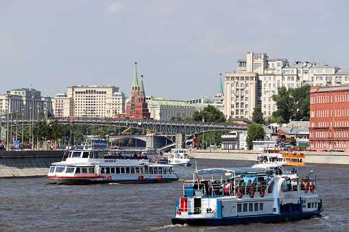 Moscow, Russia - July 2020: View of the Moscow river and tourist boats on water. Moscow panorama with Kremlin and State duma building on blue sky background