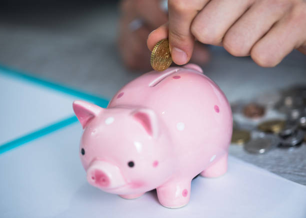 istock man hand coins with piggy bank 1255790544