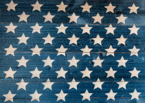 istock White stars on blue wooden board background 1255792971