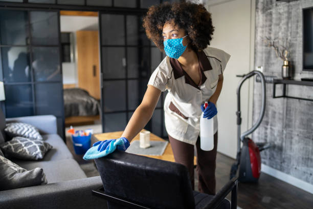 cameriera afro con maschera protettiva per il viso durante la pulizia di una camera d'albergo in tempo di pandemia di covid-19 - home interior sparse bedroom inside of foto e immagini stock