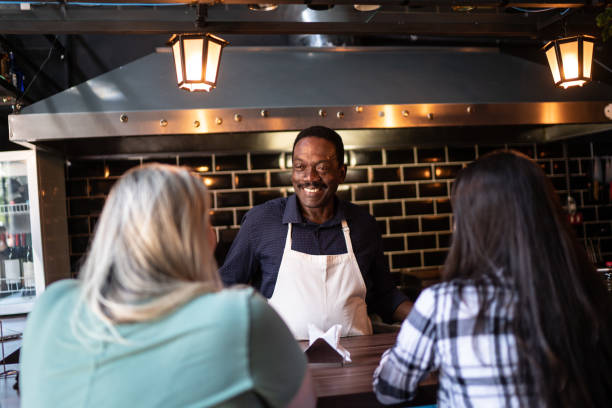 istock Barista serving ant talking to customers at the restaurant 1255798431
