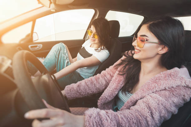 istock Two happy young women having fun in a car 1255800754