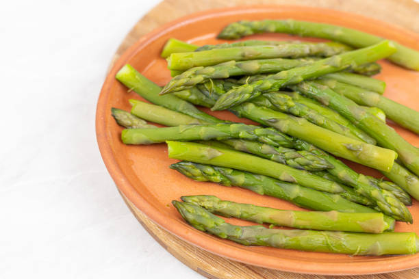 istock Cooked asparagus on the wooden board. 1255802629