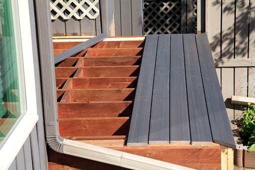 Close Up view of partially build residential deck from side view. Real wood structure with composite material planks.