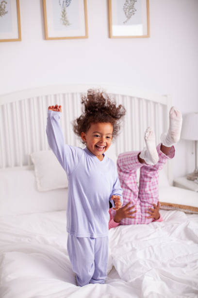 istock African-American kids having a fun time jumping on a bed 1255808847