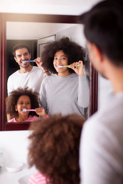 istock Young mixed family are brushing their teeth in the bathroom 1255808988