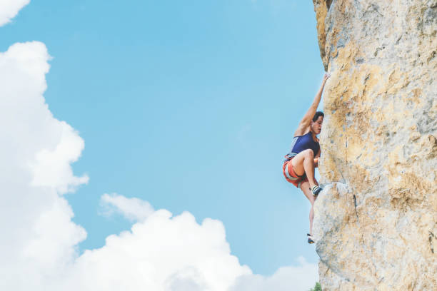 istock Woman climbs a rock. 1255814211